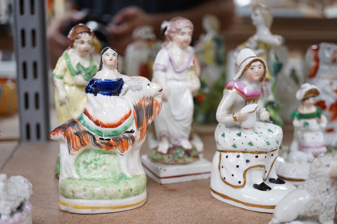 A collection of 19th century and later Staffordshire figures, mostly figural examples, including a pair a rare pair of porcelain seated figures with rabbits and a candle extinguisher, largest 15cm high (15)